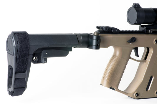 A modern AR-15 pistol equipped with a stabilizing brace lies on a tactical mat, representing the ongoing legal controversy surrounding pistol braces in the U.S.